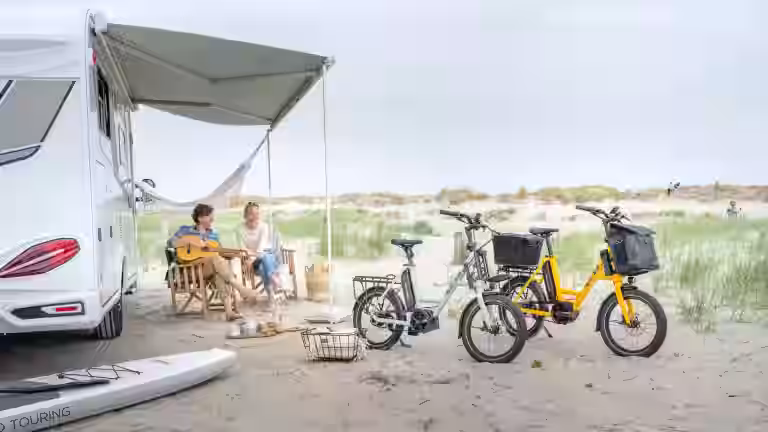 Elke und Andreas entspannt vor ihrem Wohnmobil mit zwei iSY E5 ZR F Kompakträdern auf dem Campingplatz