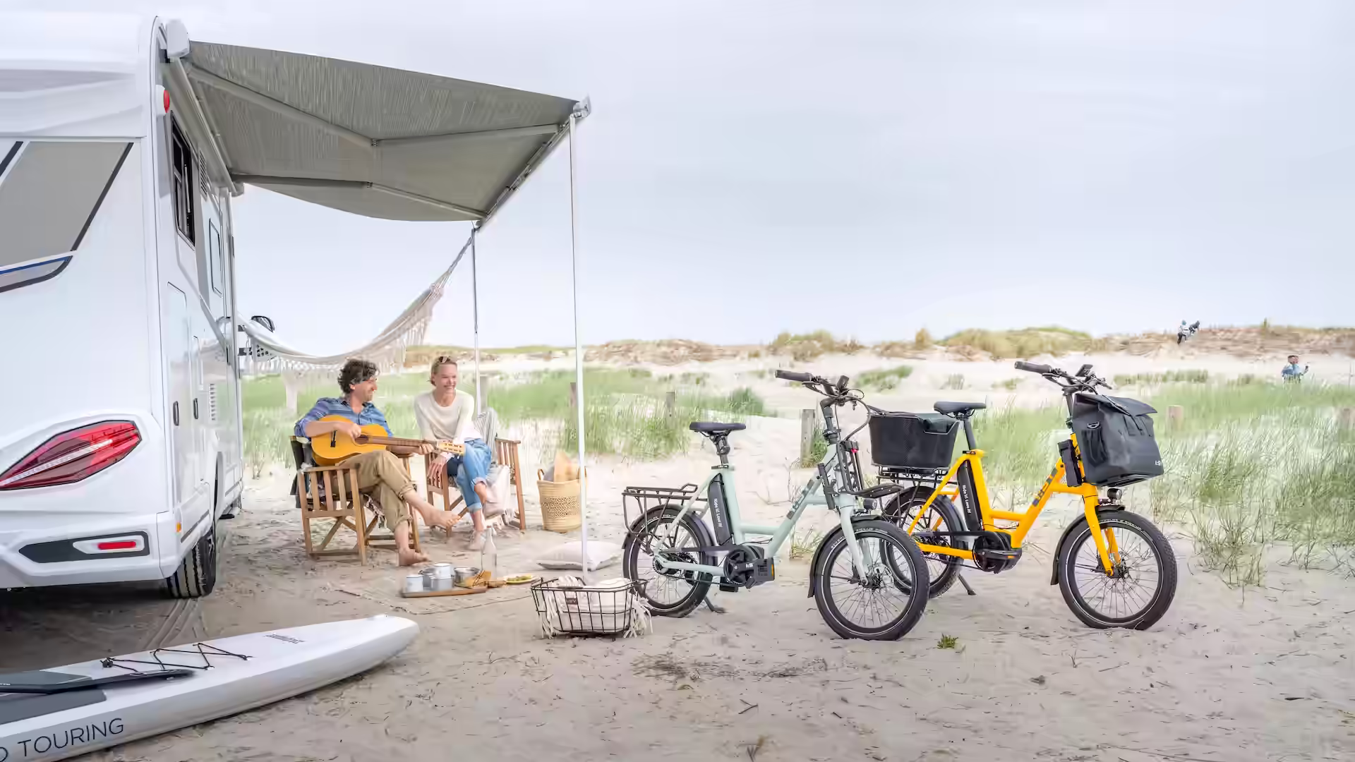 Elke und Andreas entspannt vor ihrem Wohnmobil mit zwei iSY E5 ZR F Kompakträdern auf dem Campingplatz